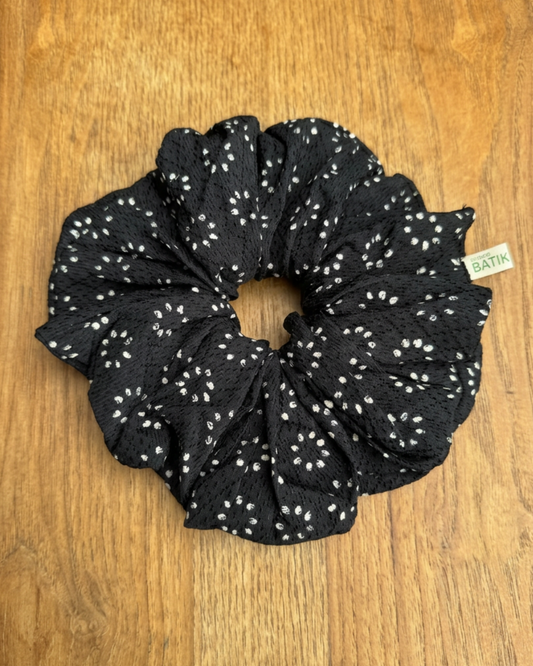 Black scrunchie with white pattern on a wooden surface