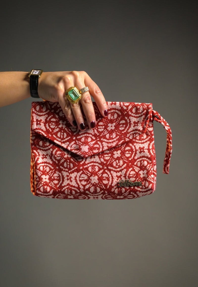 A woman holding a red kompas Batik clutch 
