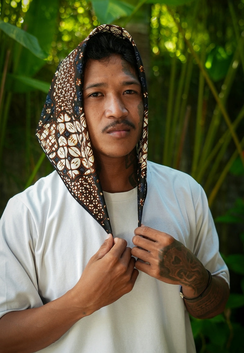 Man wearing a patterned headscarf with a natural background batik sekar jagad