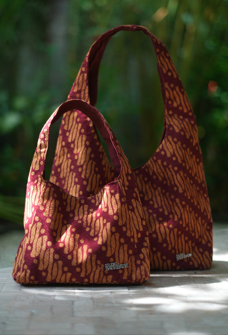 Batik Patterned handbag on a white surface with a blurred green background