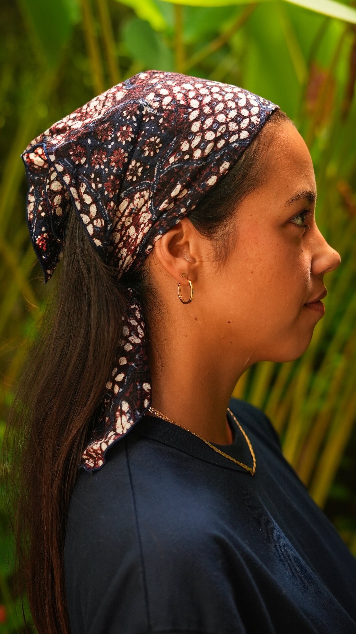 Woman wearing a batik headscarf in a natural setting