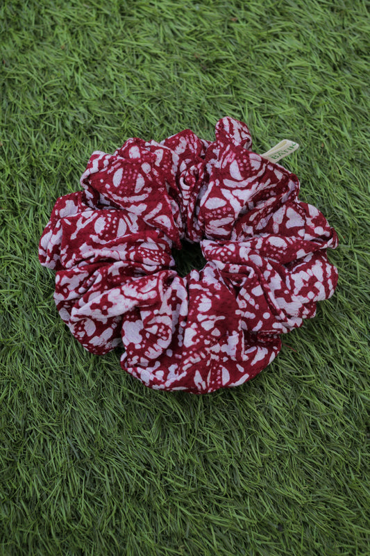Red and white patterned batik  scrunchie on green grass