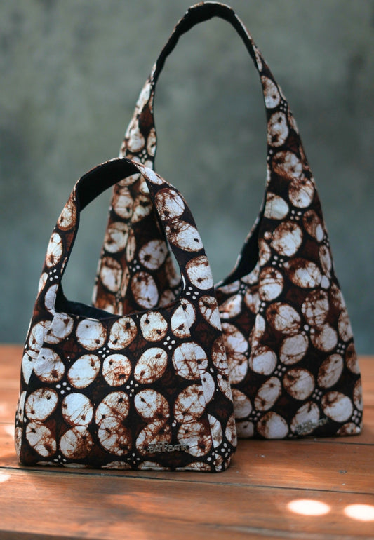 Two patterned handbags on a wooden surface with Batik Kawung