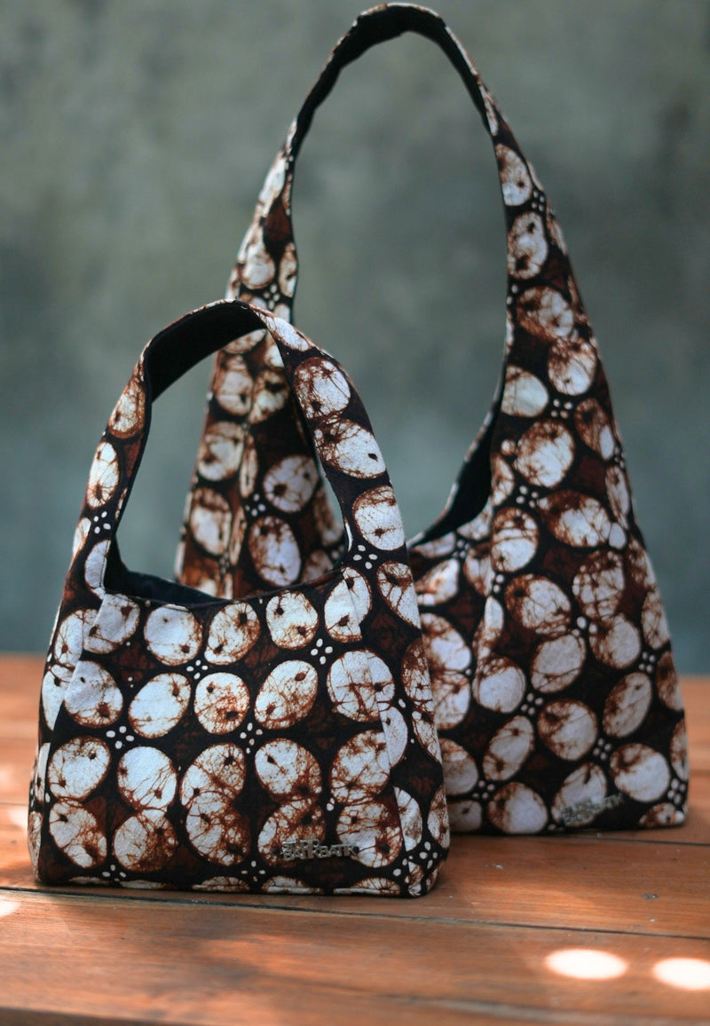Two patterned handbags on a wooden surface with Batik Kawung